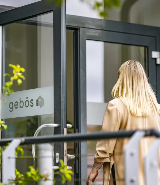 Frau betritt das Gebäude der gebös